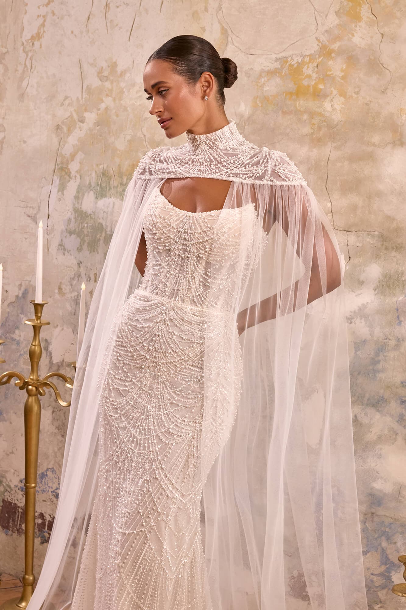 Luxury lace mermaid wedding dress Avore featuring an illusion corset, floral lace appliqués and an elegant detachable cape.