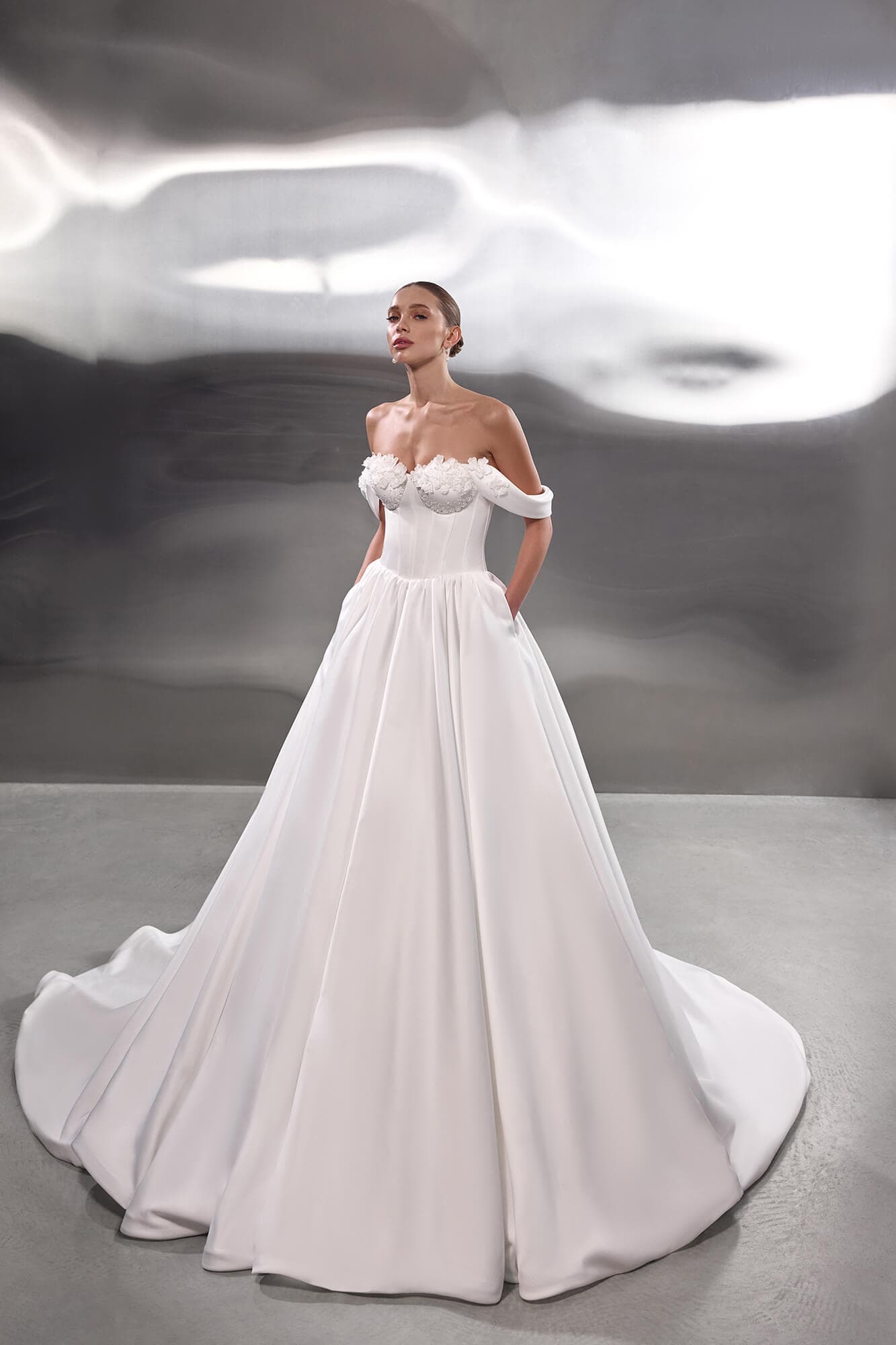 Modern satin A-line wedding dress Chelsea with structured corset, elegant draping and flowing chapel train.