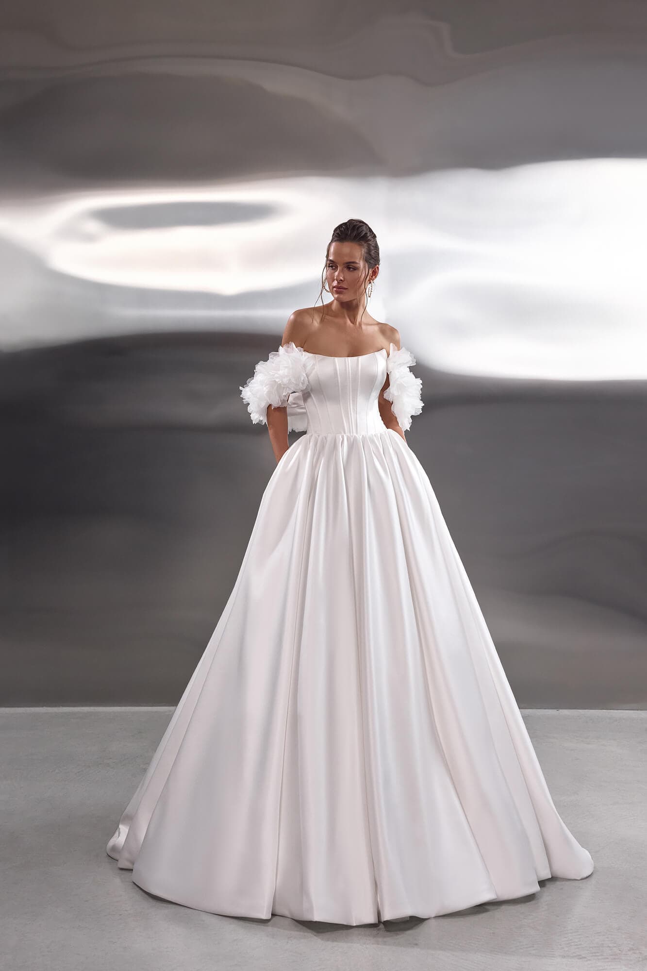 Elegant lace mermaid wedding dress Nerina featuring an illusion corset, floral lace appliqués and a graceful chapel train.