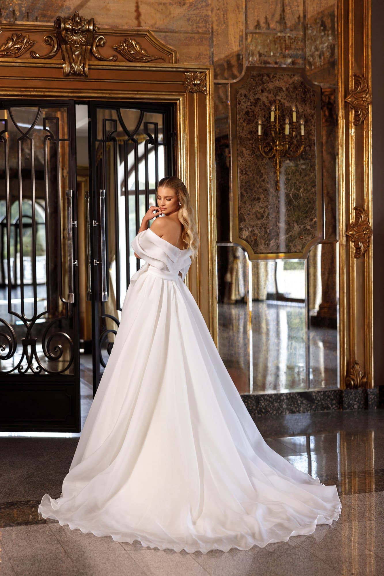 Romantic princess wedding dress Rona featuring an illusion corset, floral lace appliqués, layered tulle skirt and elegant cathedral train.