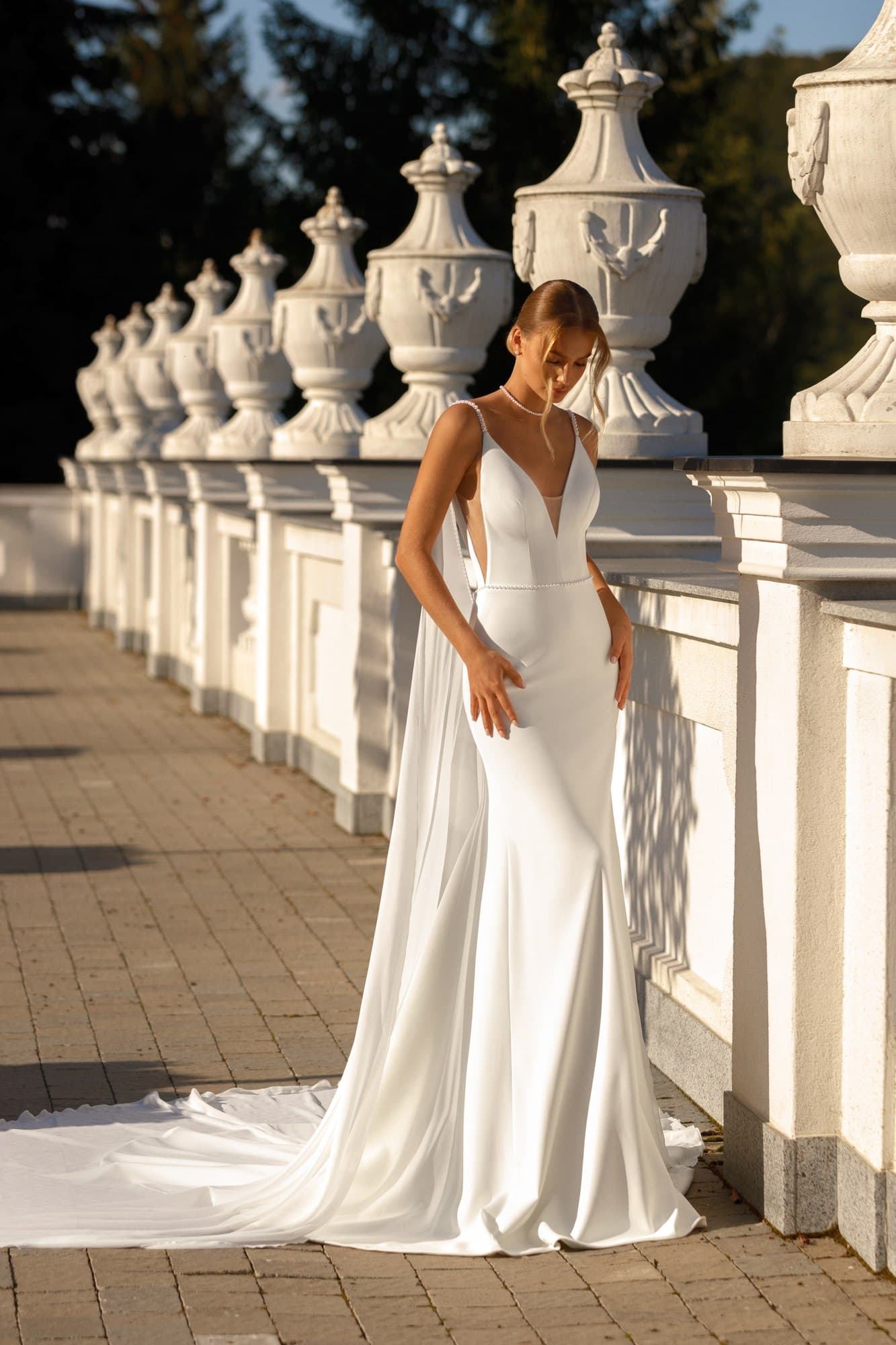 Modern satin A-line wedding dress Elison with deep V-neckline, delicate spaghetti straps, open back and elegant chapel train.