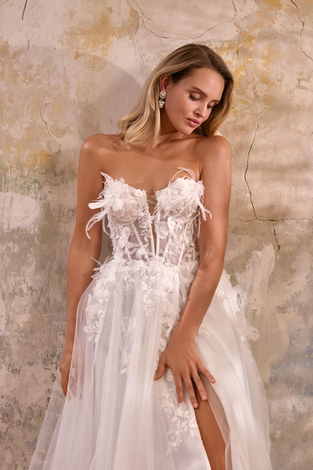 Elegant lace mermaid wedding dress Eveline featuring an illusion corset, floral lace appliqués, fitted silhouette and graceful chapel train.
