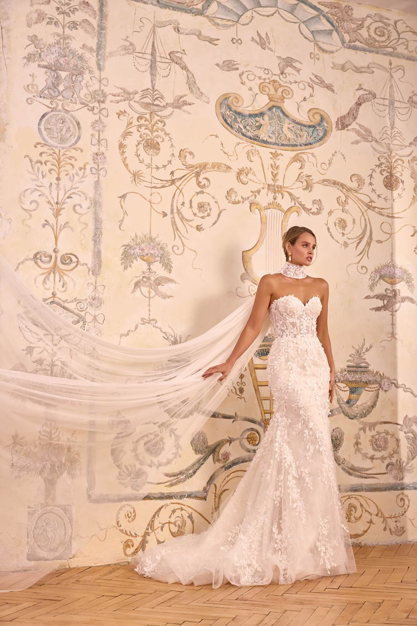 Luxury floral A-line wedding dress Florena featuring an illusion corset, delicate floral lace appliqués, flowing tulle skirt and elegant chapel train.