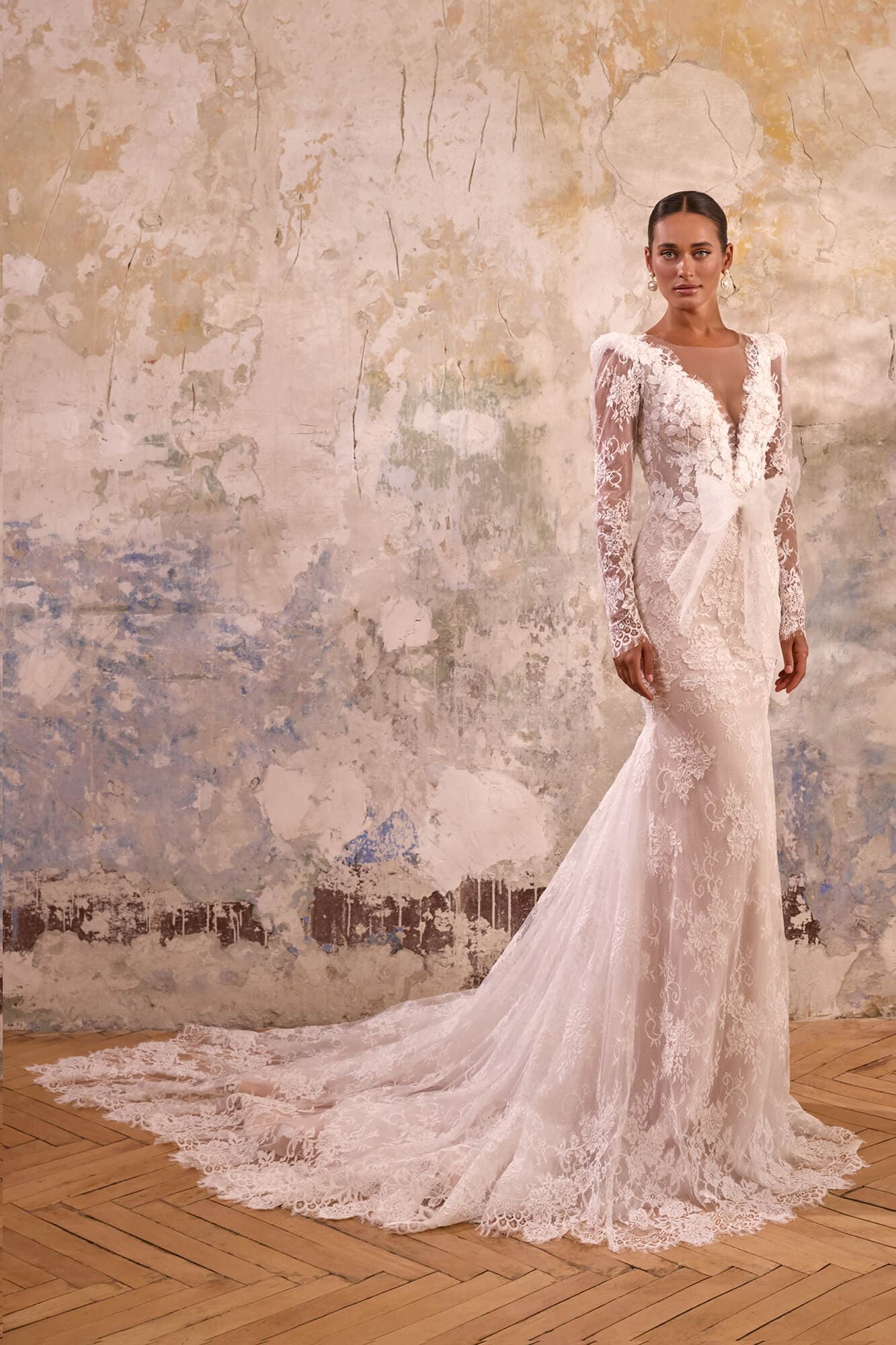 Elegant A-line wedding dress Grace featuring an illusion corset, delicate floral lace appliqués, flowing skirt and graceful chapel train.